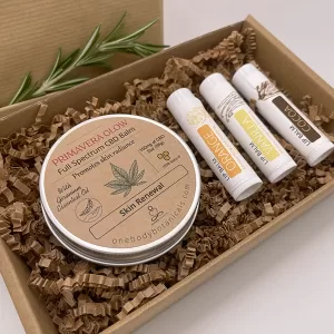 2oz can of Primavera Glow, Geranium and Shea Butter and Full Spectrum CBD Skin Balm and threee lip balms: Orange, Vanilla and Cocoa Flavor set in a ready to wrap eco-friendly box. OneBody Botanicals